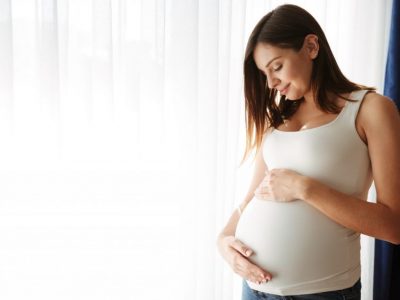 portrait of happy pregnant woman touching her belly scaled e